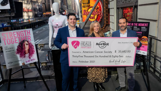 Gerard Bellini, right, of Hard Rock Cafe New York, presents Marie Cimaglia and Austin DeSavino, of American Cancer Society, with a donation check in honor of Hard Rock’s PINKTOBER Breast Cancer Awareness fundraising efforts, Tuesday, Nov. 9, 2021.