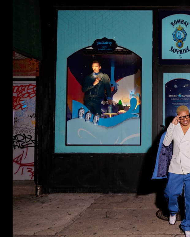 Romeo Hunte stands in front of his Bombay Sapphire  Holiday Storefront Series window.