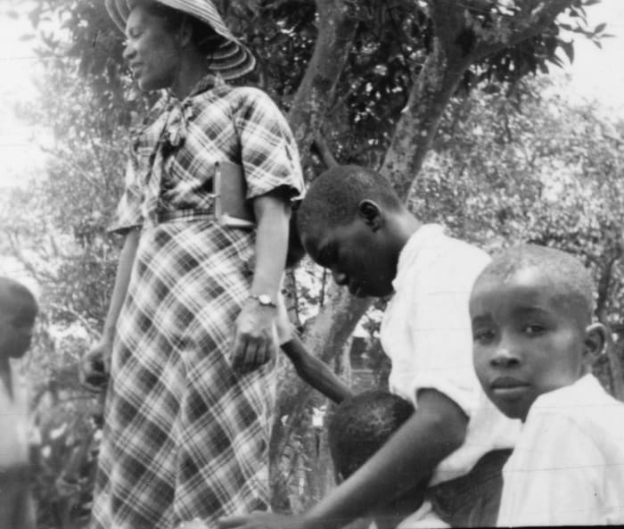 Zora Neale Hurston plays with children in Eatonville, Florida. This photo was taken during the Lomax-Hurston-Barnicle recording expedition to Georgia, Florida, and the Bahamas. June 1935.