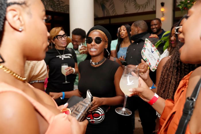 Essence Fest headliner Janelle Monae kept it casual for the daytime occasion and made a beeline to the dance floor in a simple black T-shirt, accessorized by a chunky chain necklace, her signature black hat, and round sunglasses.