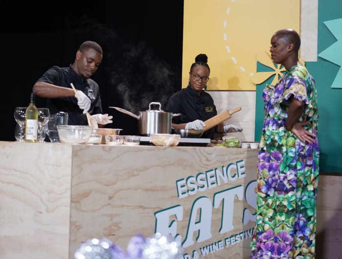 Sidra Smith looks on as Chefs Brooks and Hyman demonstrate how to prepare signature dishes from Saint-Martin.