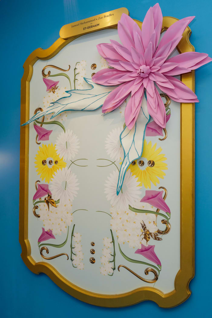 A print Jameel Mohammed designed for Fleuriste St-Germain is punctuated with a paper flower that blooms beyond the gold frame.