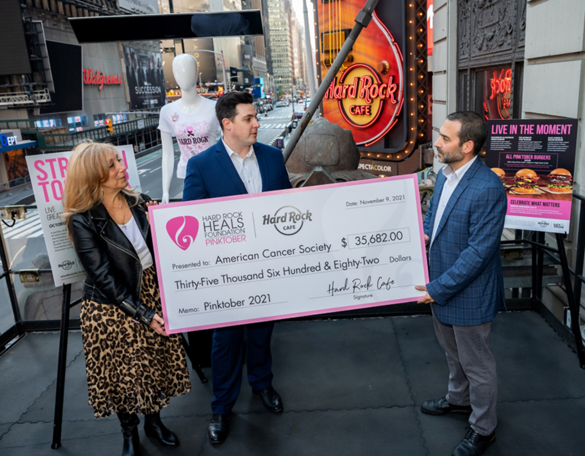 Marie Cimaglia, Interim Vice President of Development of American Cancer Society, and Austin DeSavino, Associate Director of Development of the American Cancer Society, receive a donation from Gerard Bellini, right, General Manager of Hard Rock Cafe New York, at a check presentation on behalf of Hard Rock’s PINKTOBER Breast Cancer Awareness fundraising efforts benefiting the American Cancer Society, Tuesday, Nov. 9, 2021.